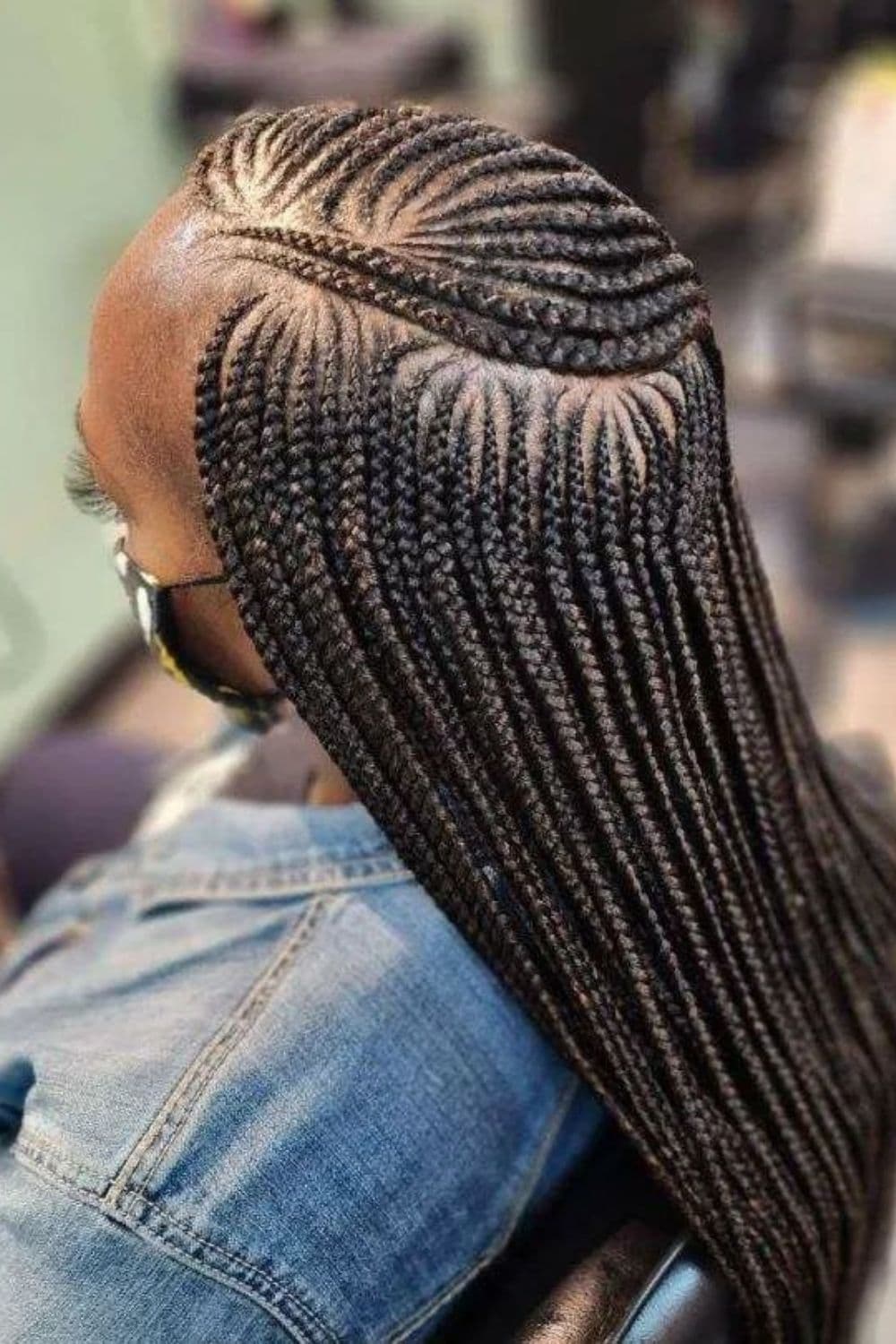 Close-up shot of a woman's micro cornrows hairstyle.