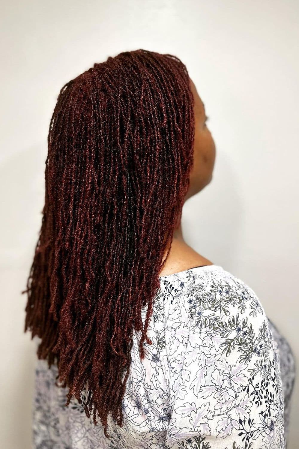 Side view of a woman with red micro twists.