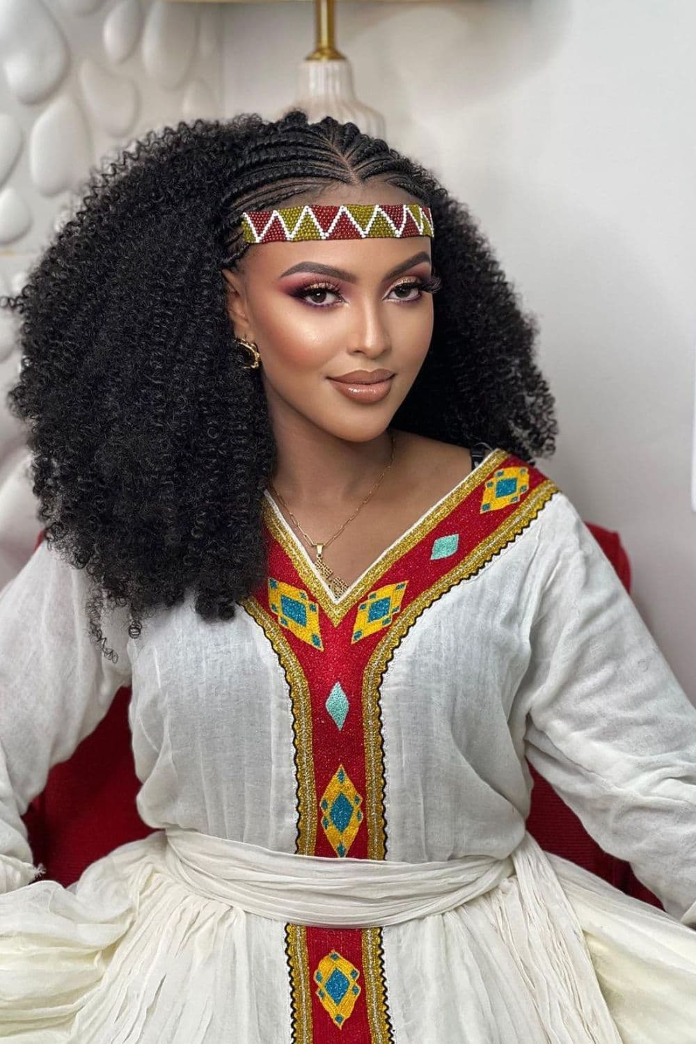 A woman wearing traditional Ethiopian clothes with middle-part Shuruba braids.