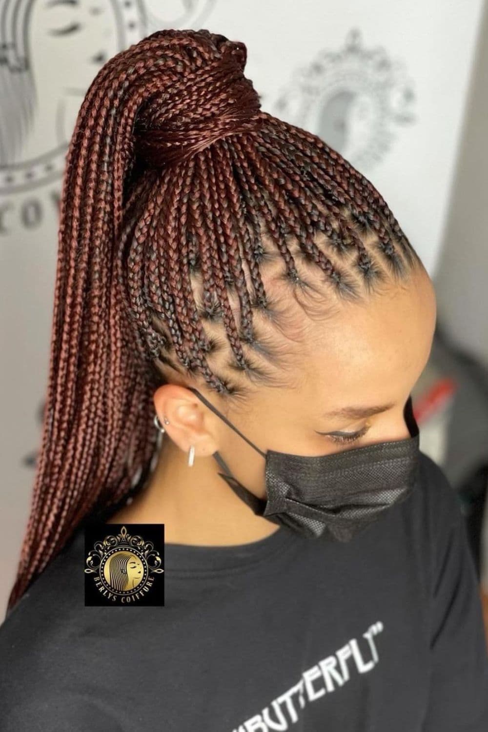 A woman wearing a black face mask with brown mini braid ponytail.