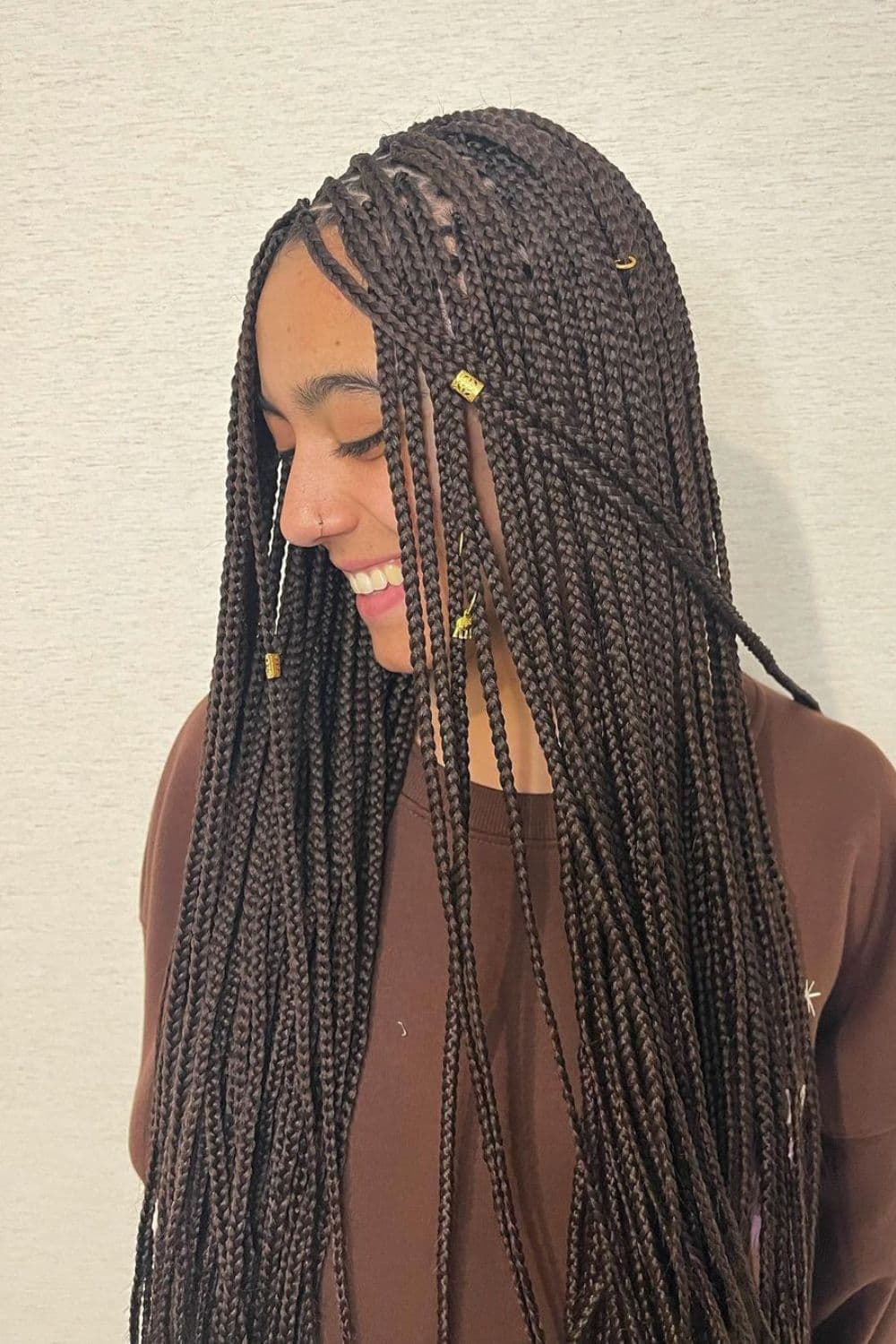 A woman with mini braids with gold cuffs.