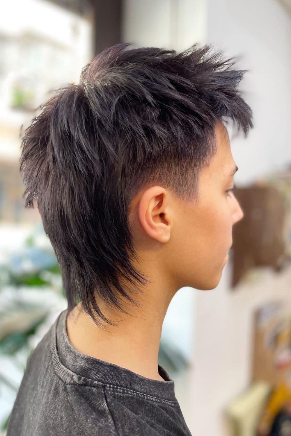 Side view of a man with mullet-style wolf cut.