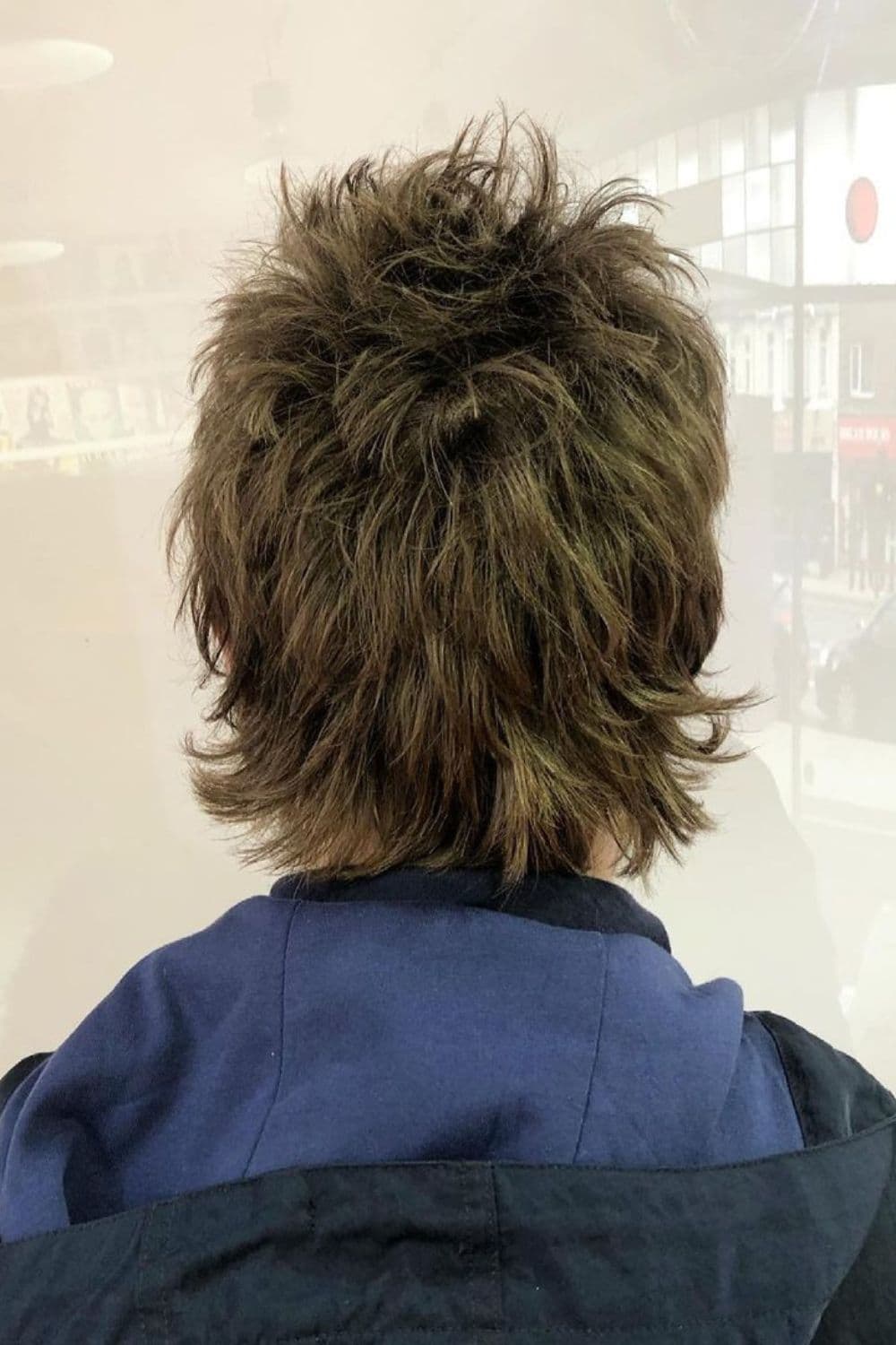Back of a man with oasis style wolf cut.