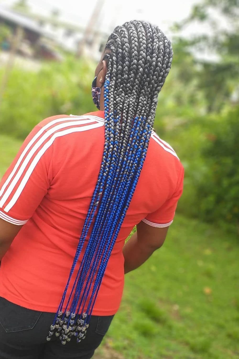 A woman with blue ombre cornrows with beads.