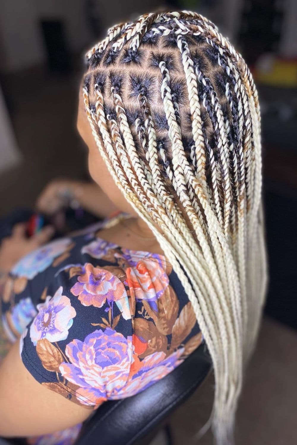 Side view of a woman with platinum blonde knotless braids.