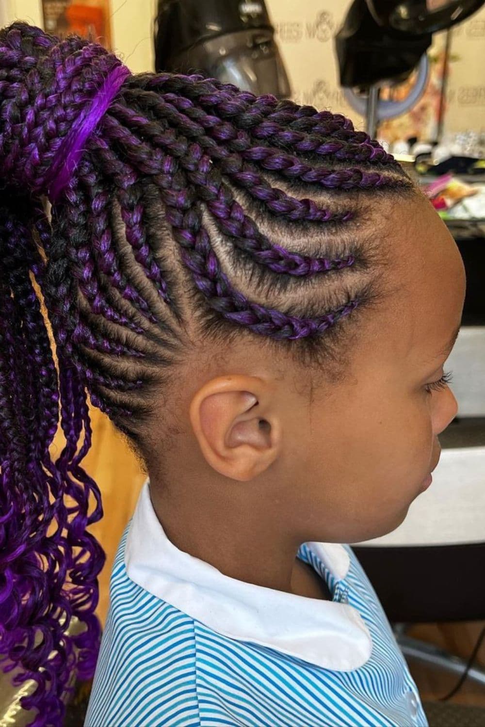 Side view of a girl with purple Fulani braids ponytail.