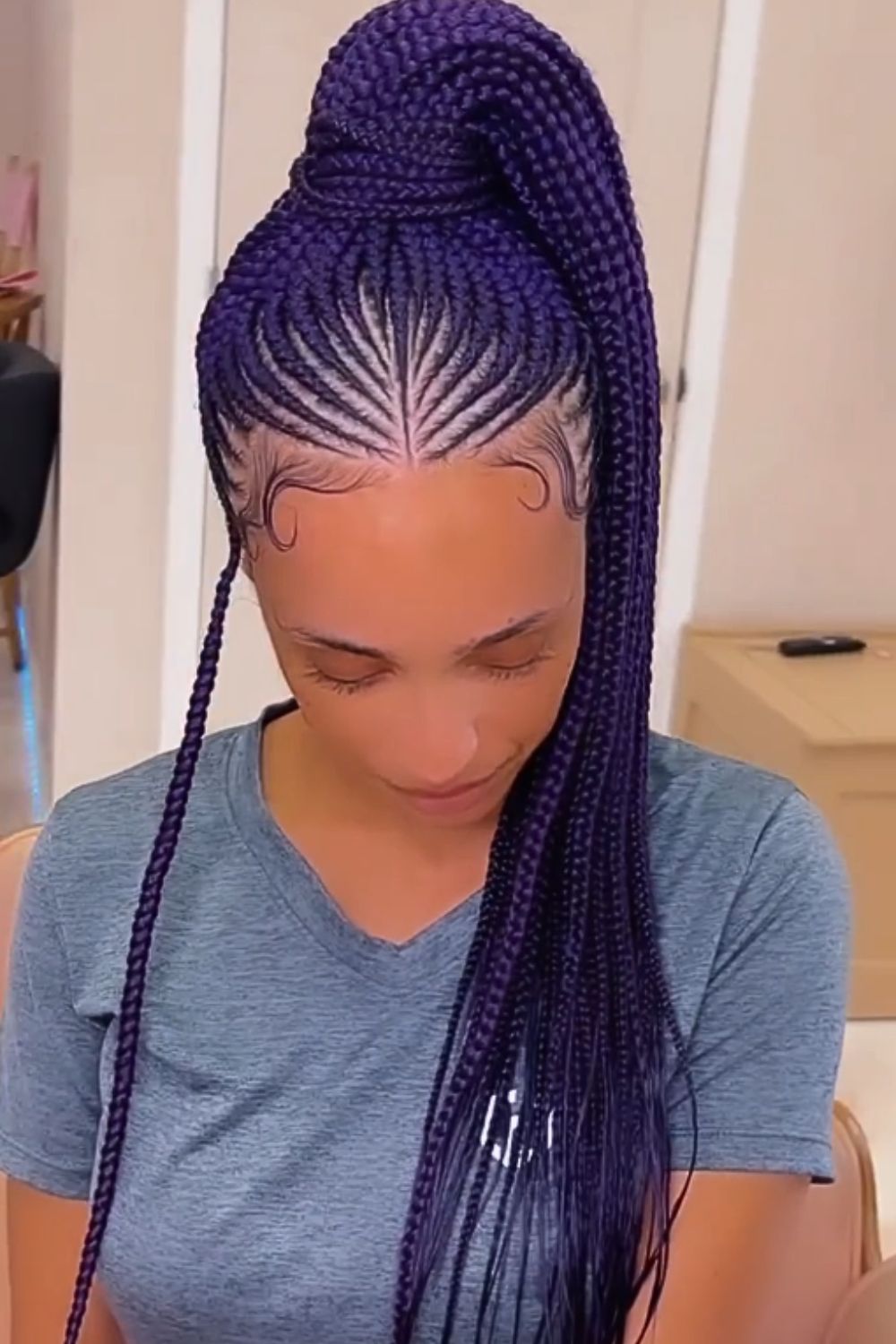 A woman with purple middle-parted tribal braids.