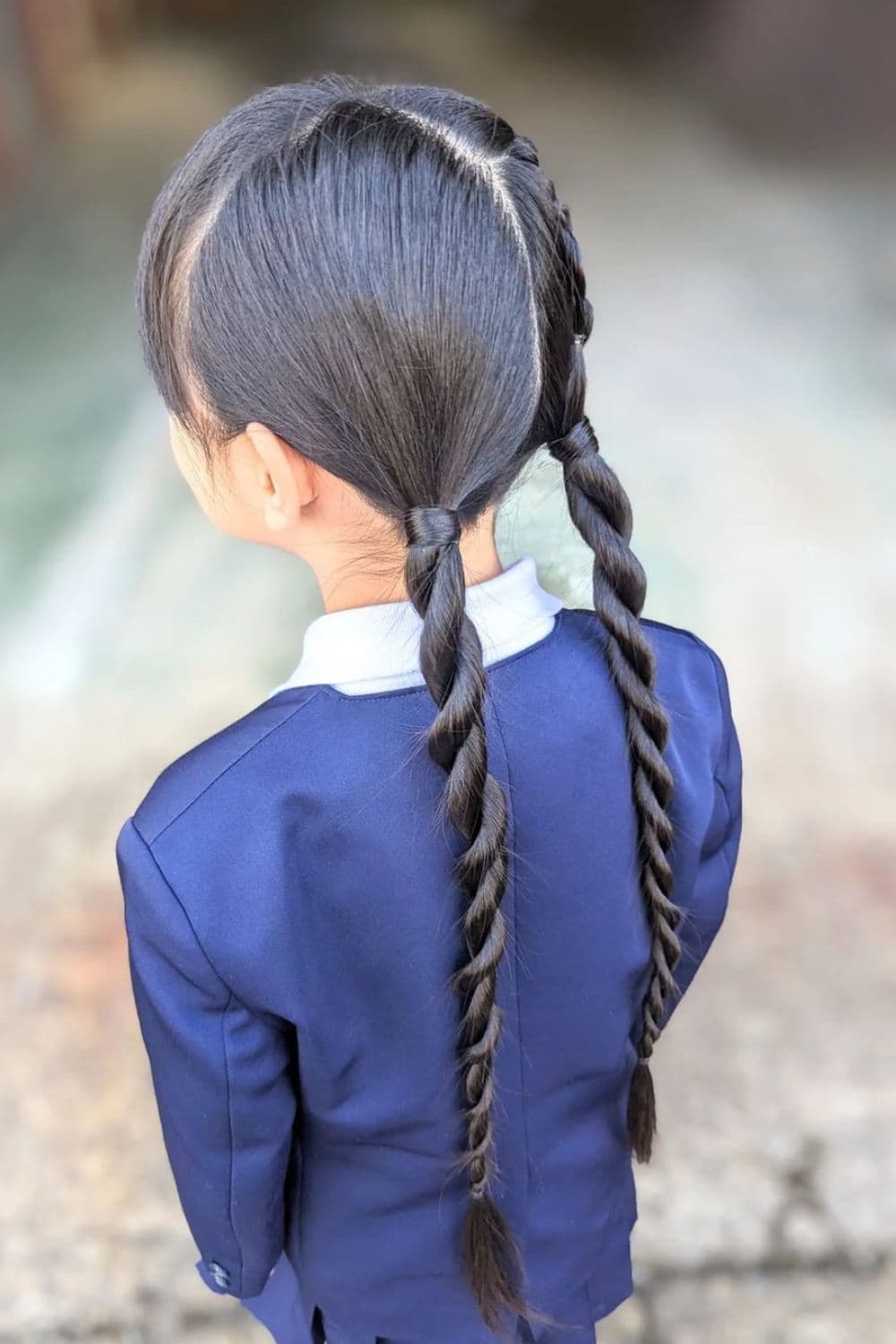 A girl wearing a Japanese uniform with a black rope braid.