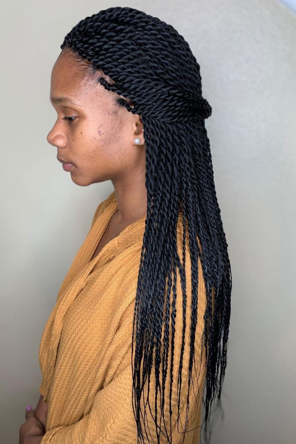 Side view of a woman standing with Senegalese twists.
