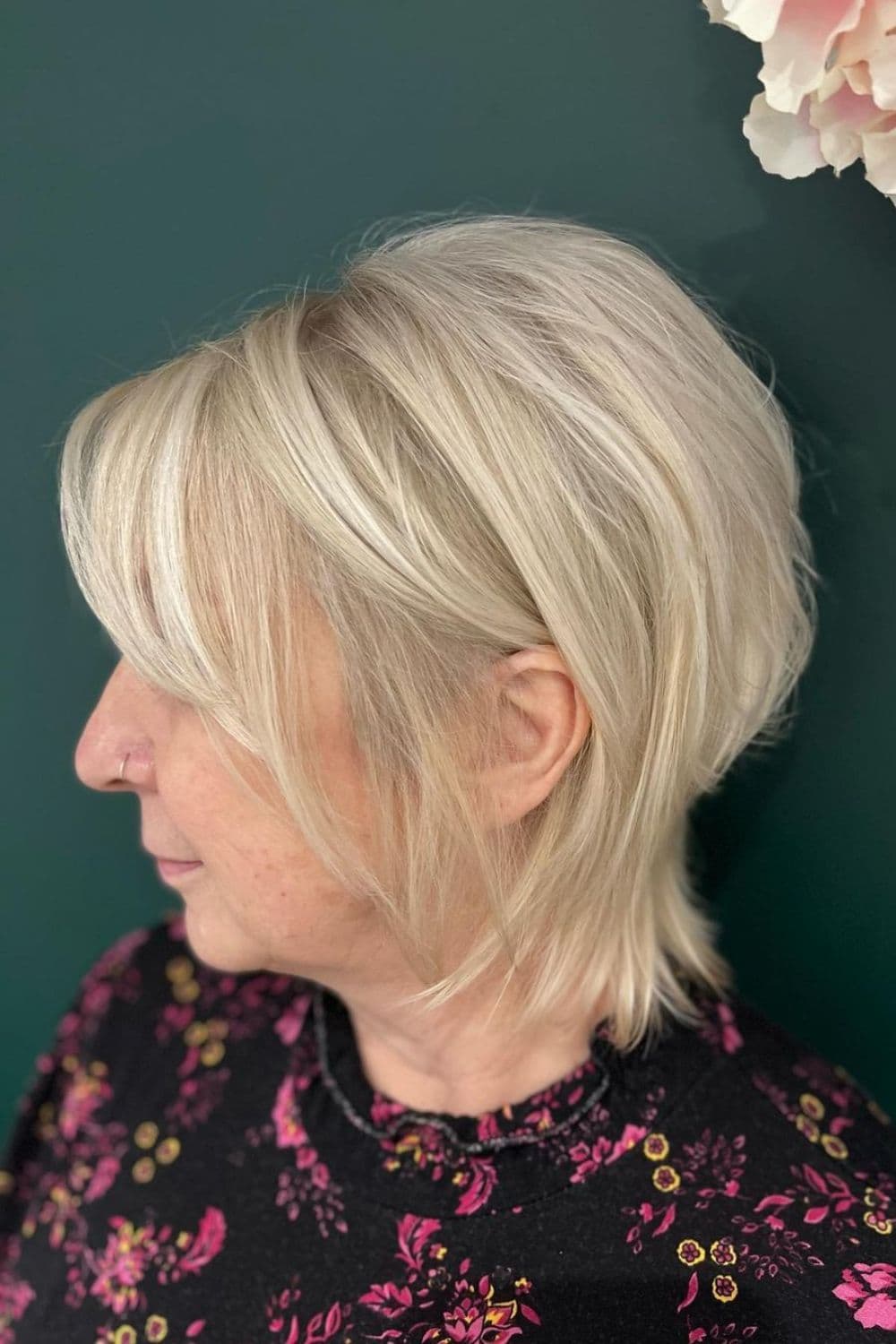 Side view of a woman with a short blonde wolf cut.
