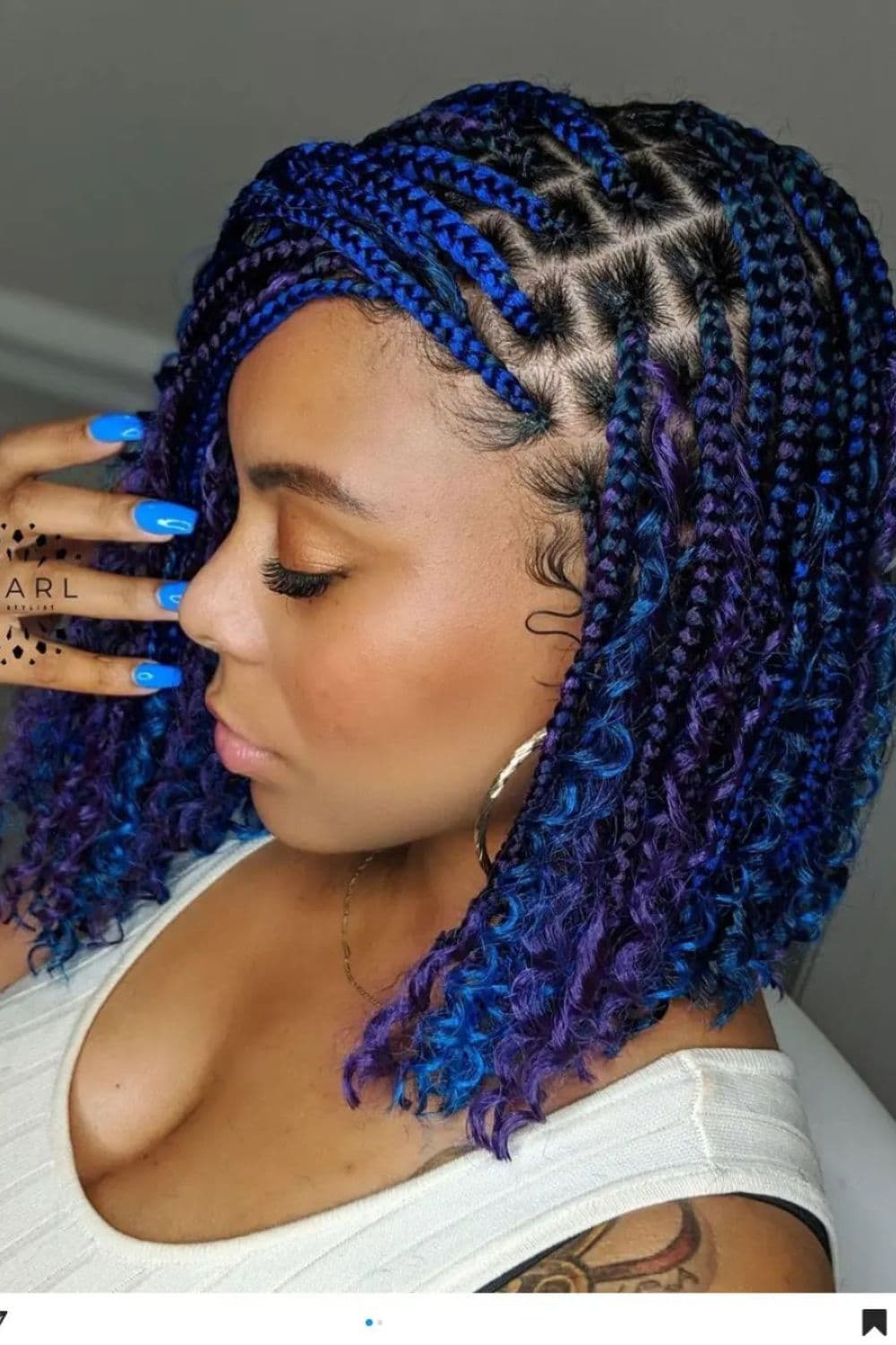 Side view of a woman with blue short medium knotless Boho braids.