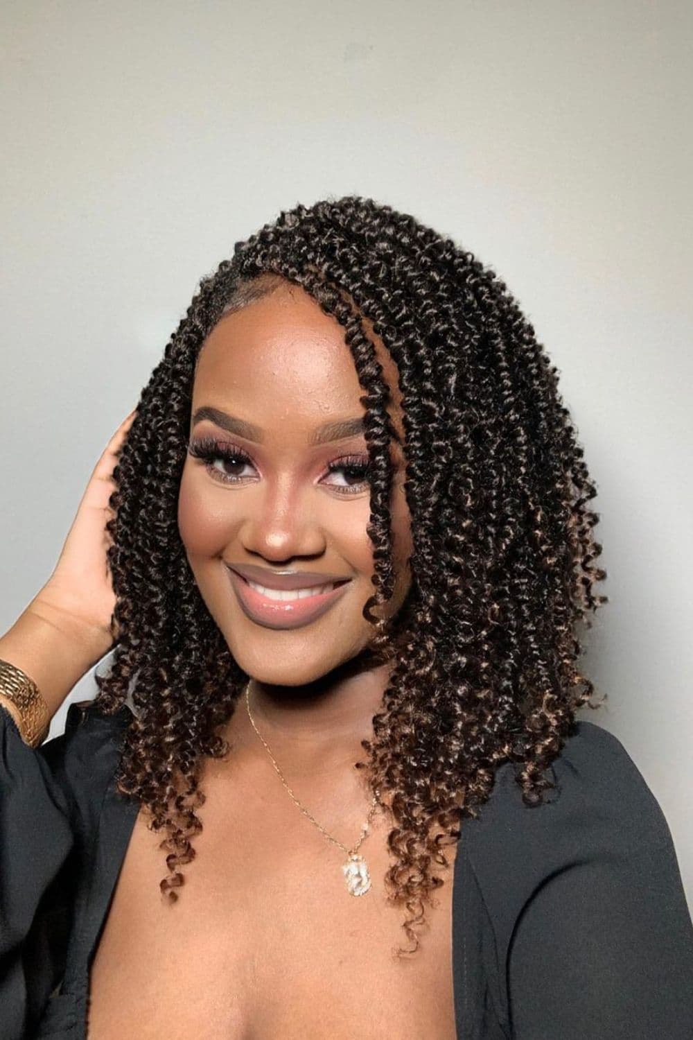 A woman with brown shoulder-length passion twists.