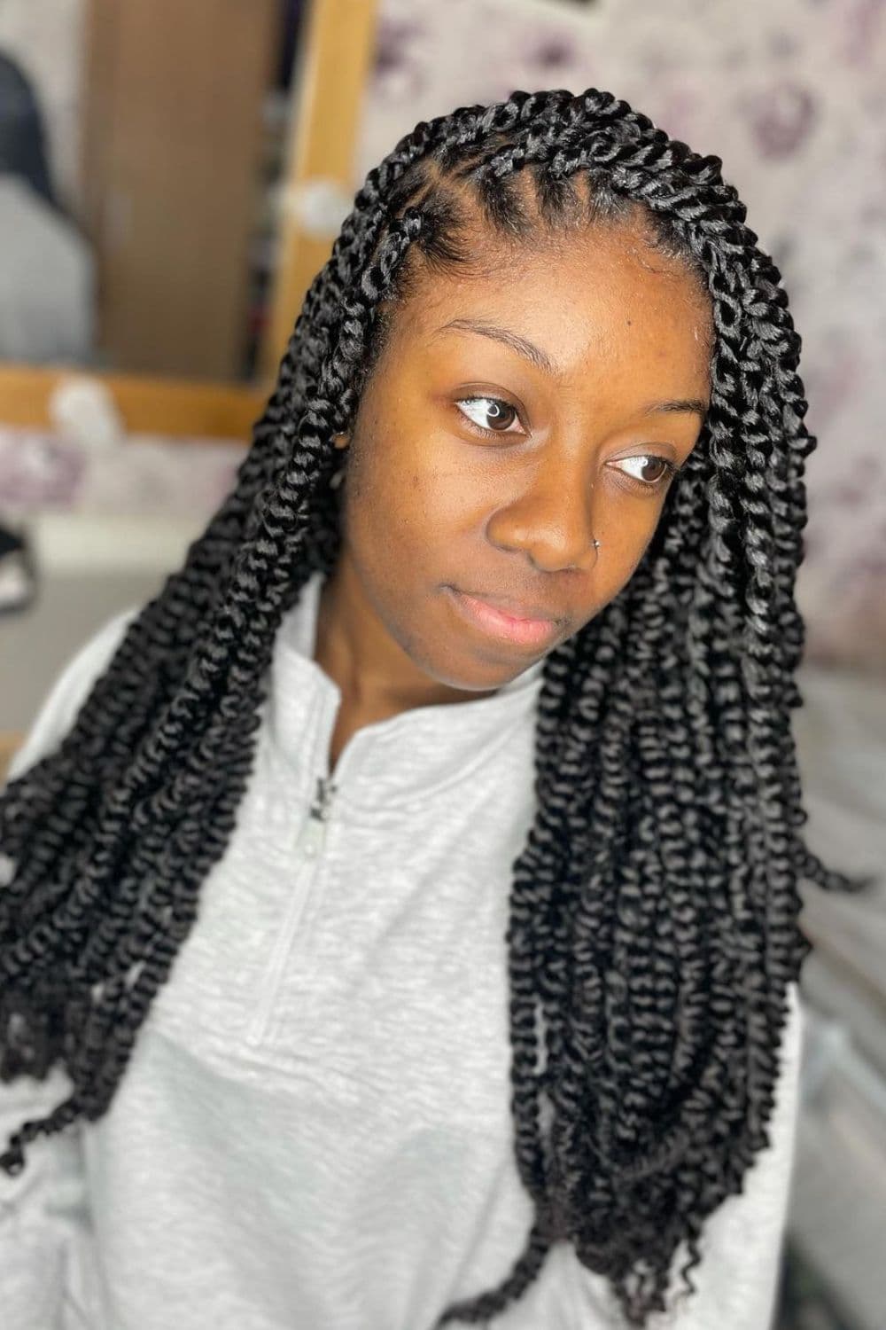 A woman with black side-parted passion twists.