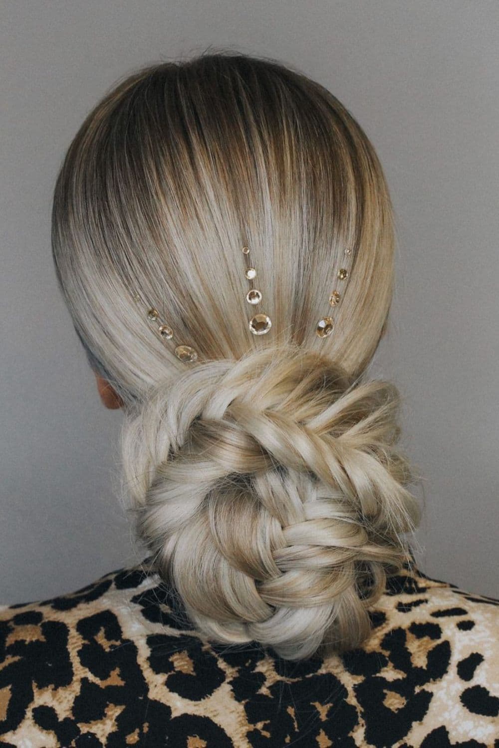 A woman with a blonde sleek low braided bun.