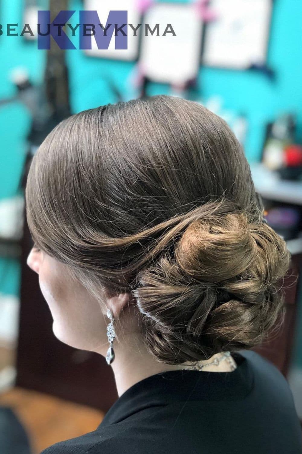 Side view of a woman with a smooth side-swept updo.