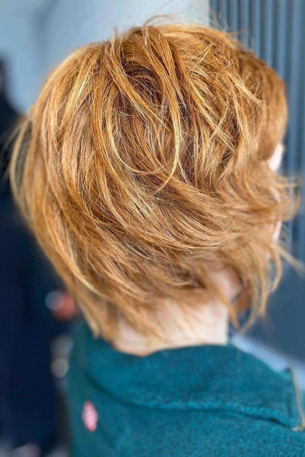 Close-up shot of a woman's hair with a blonde short, textured wolf cut.