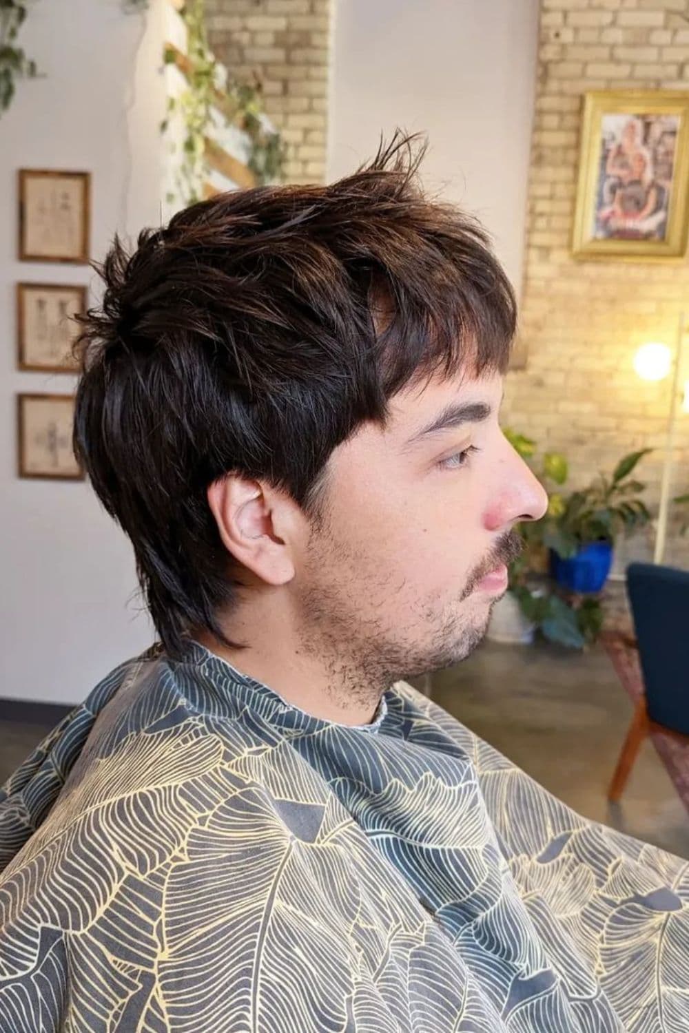 Side view of a man with textured wolf cut.
