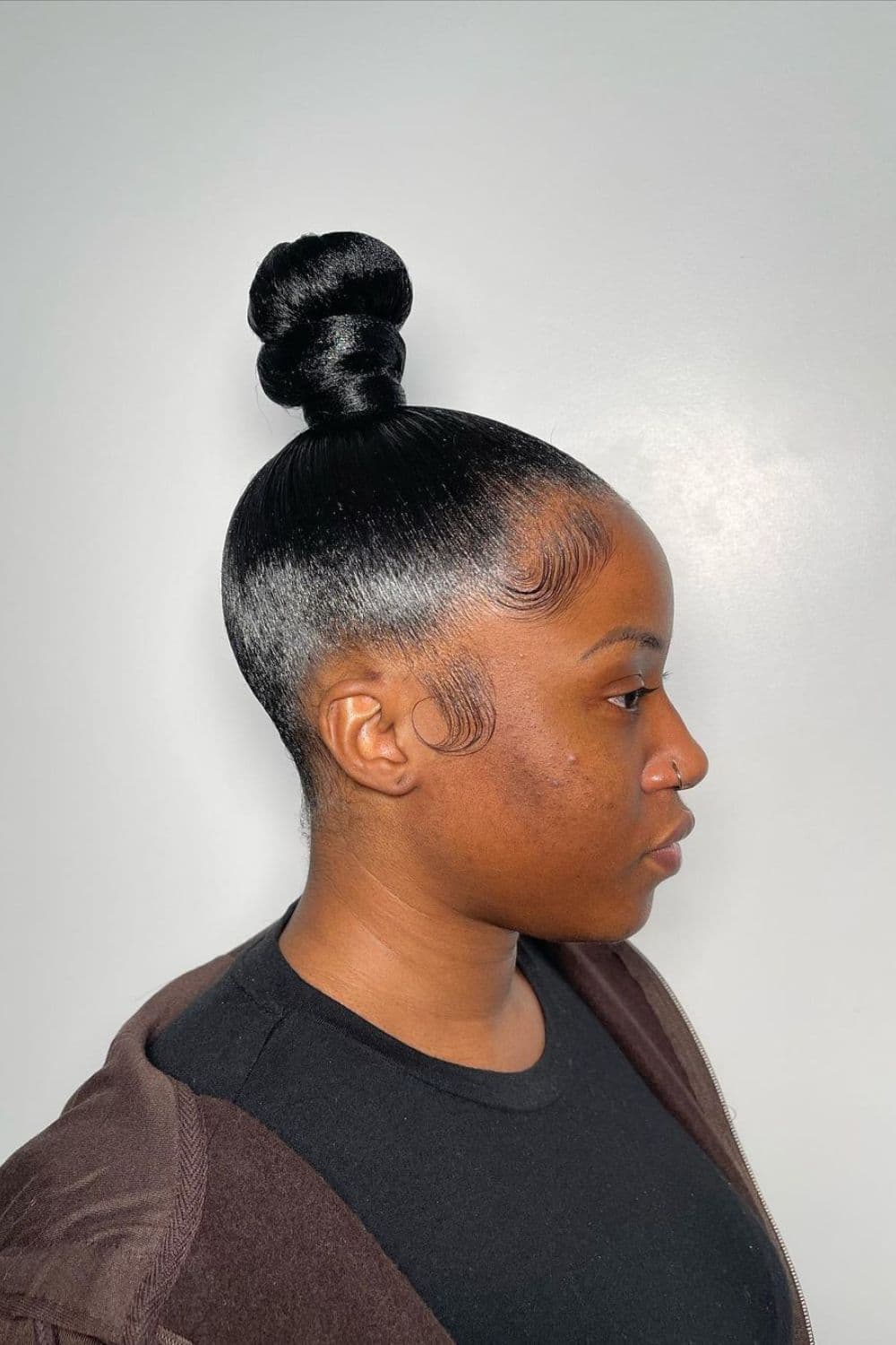 Side view of a woman with a black top knot.