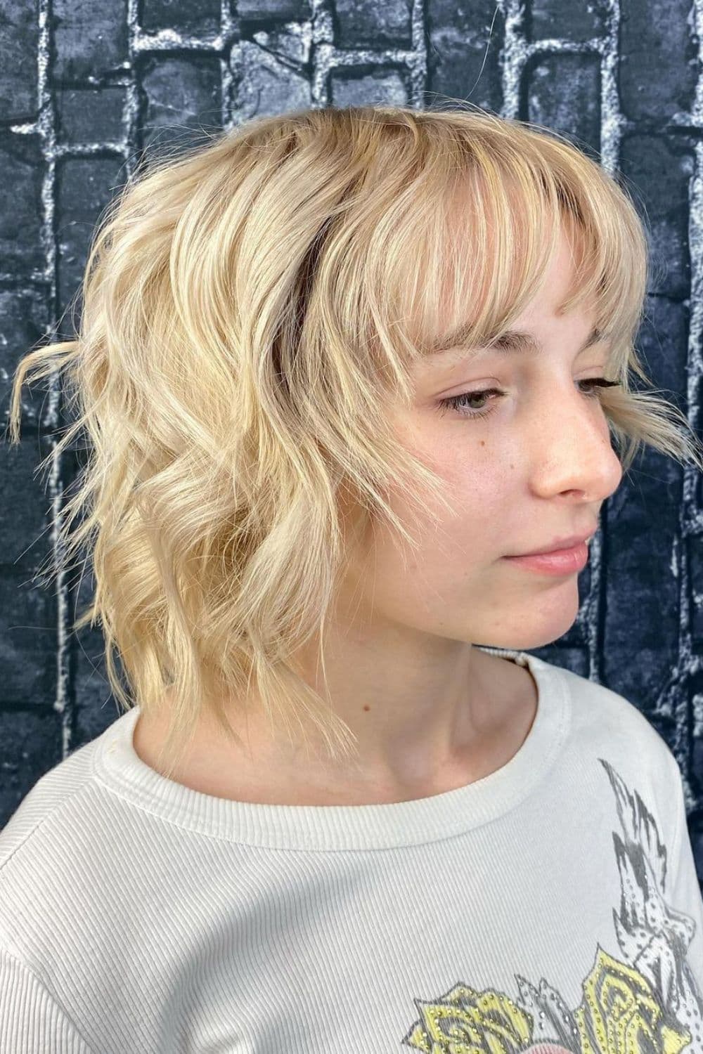 A woman with wavy tousled blonde bob cut.