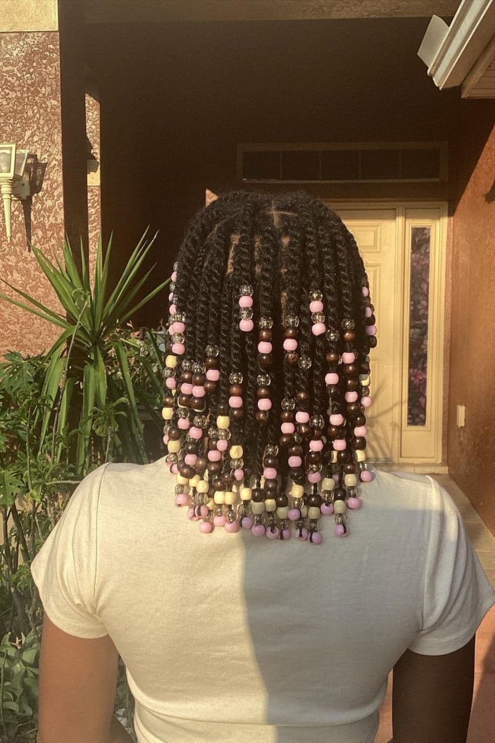A person with twists with beads hairstyle.