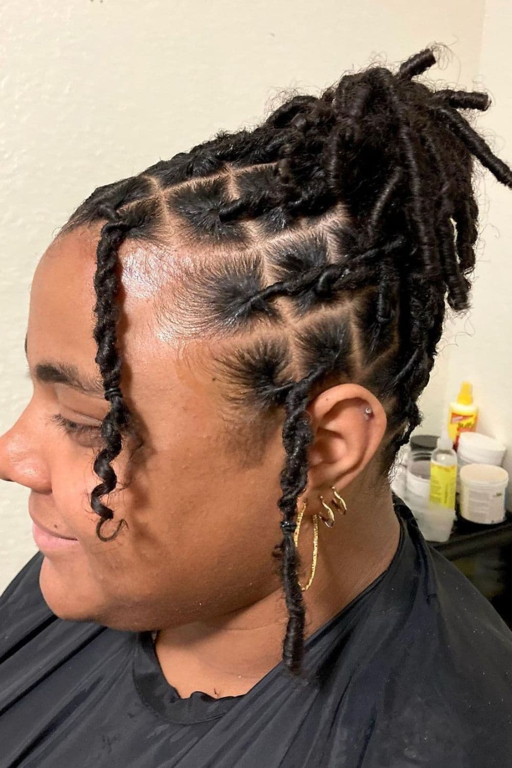 Side view of a woman with a black two-strand twist updo.