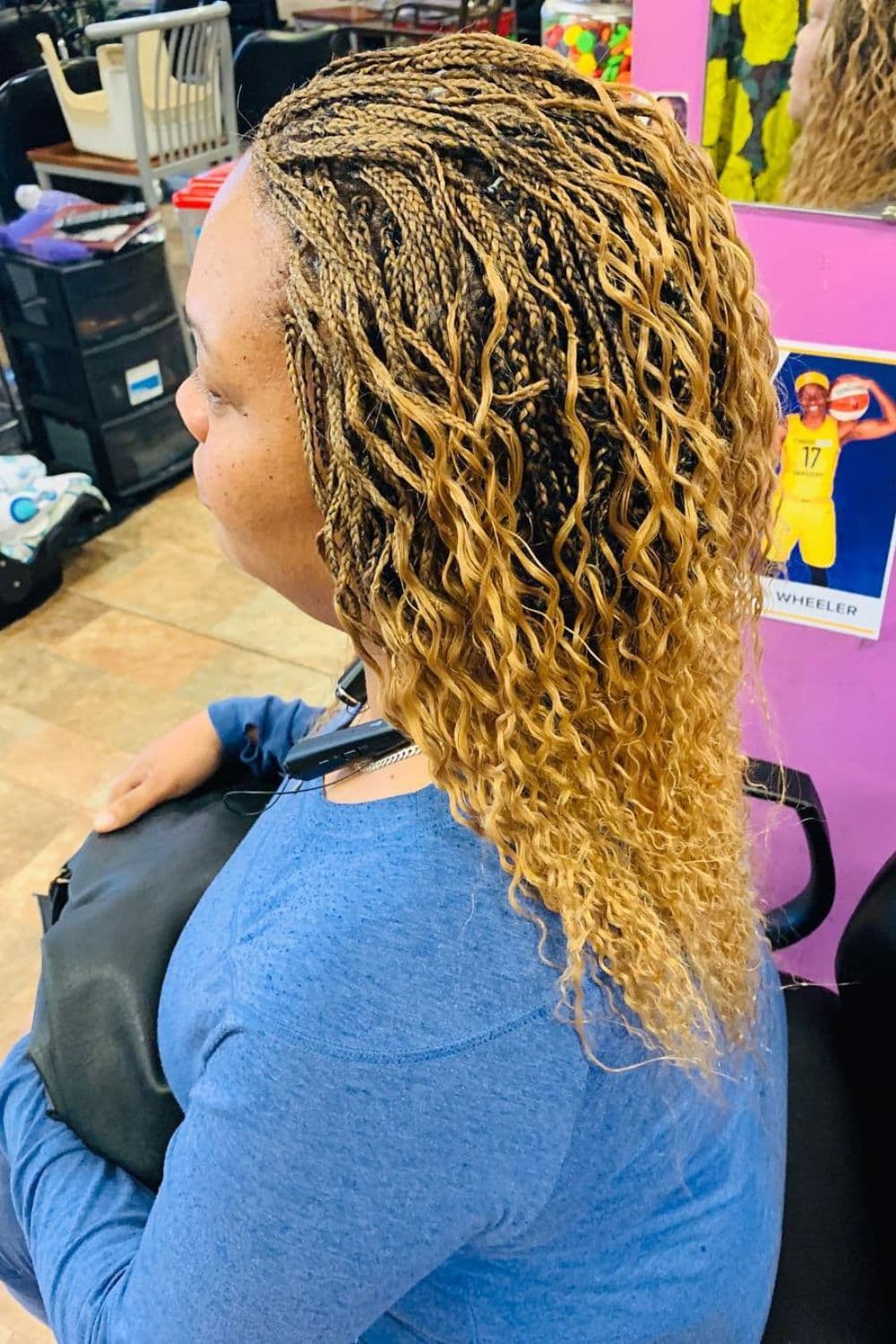 Side view of a woman with blonde and black two-tone mini braids with curly ends.