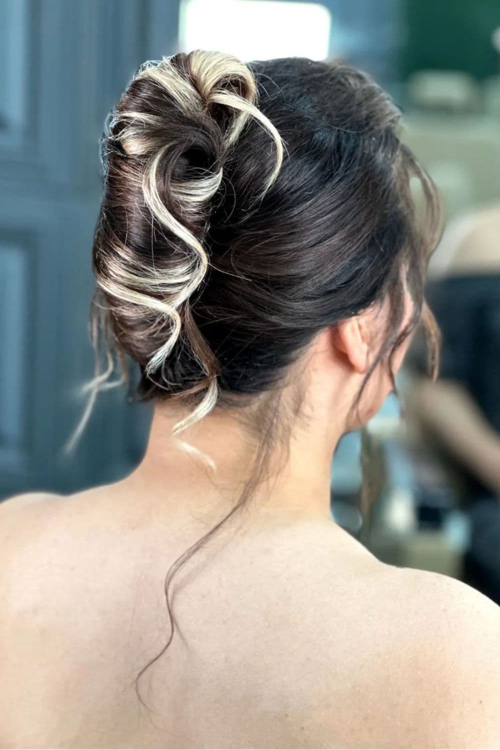 A woman with a black and blonde two-tone weave updo.