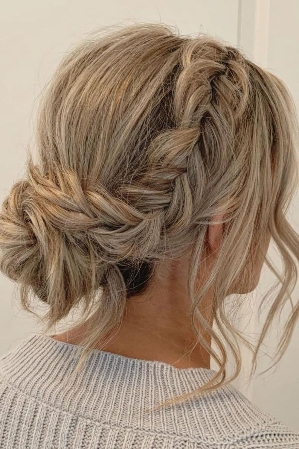 Side view of a woman with blonde updo fishtail braids.