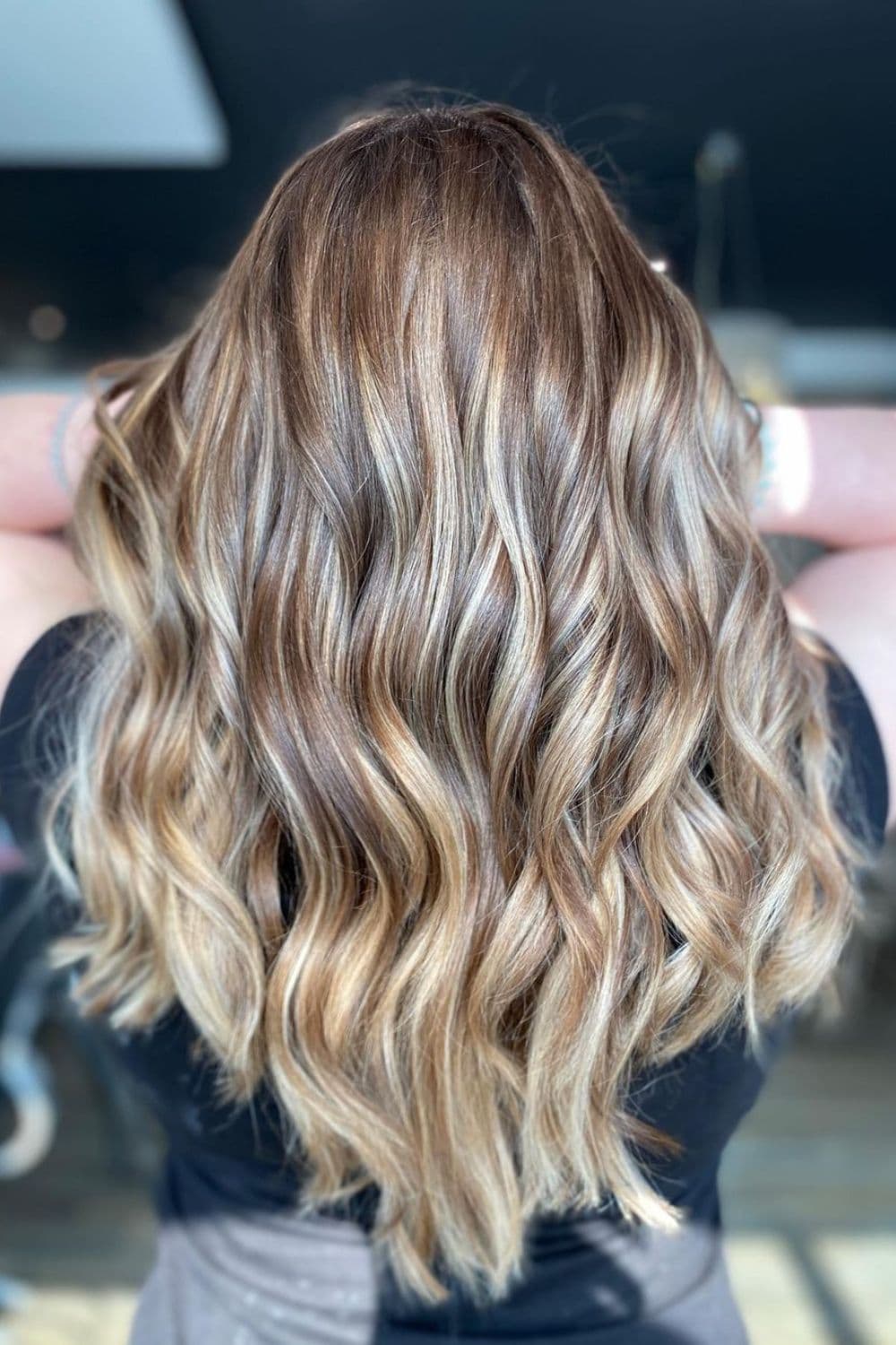 A woman's hair in blonde balayage v-cut with layers.