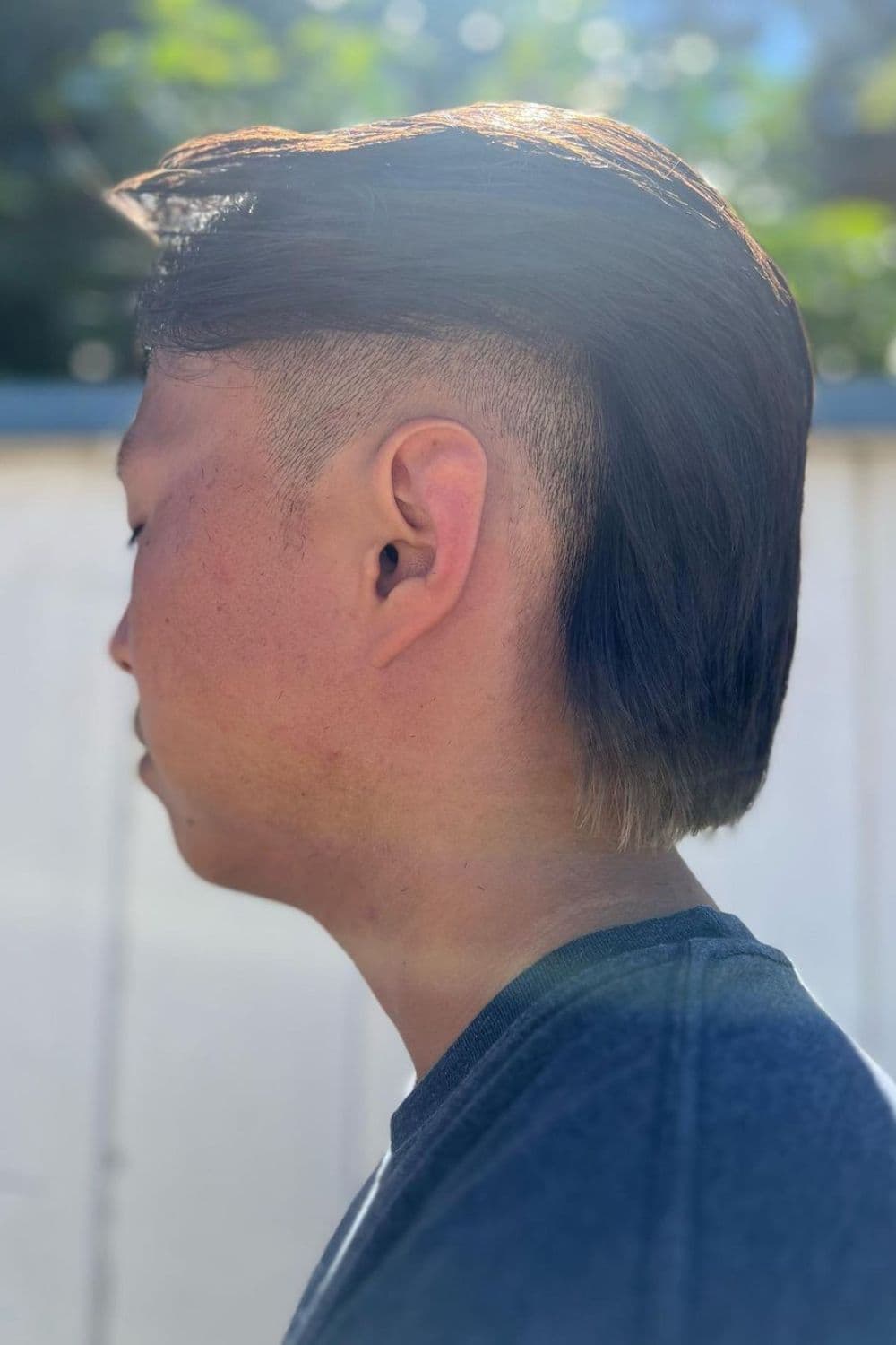 Side view of a man with a wolf cut with high fade.