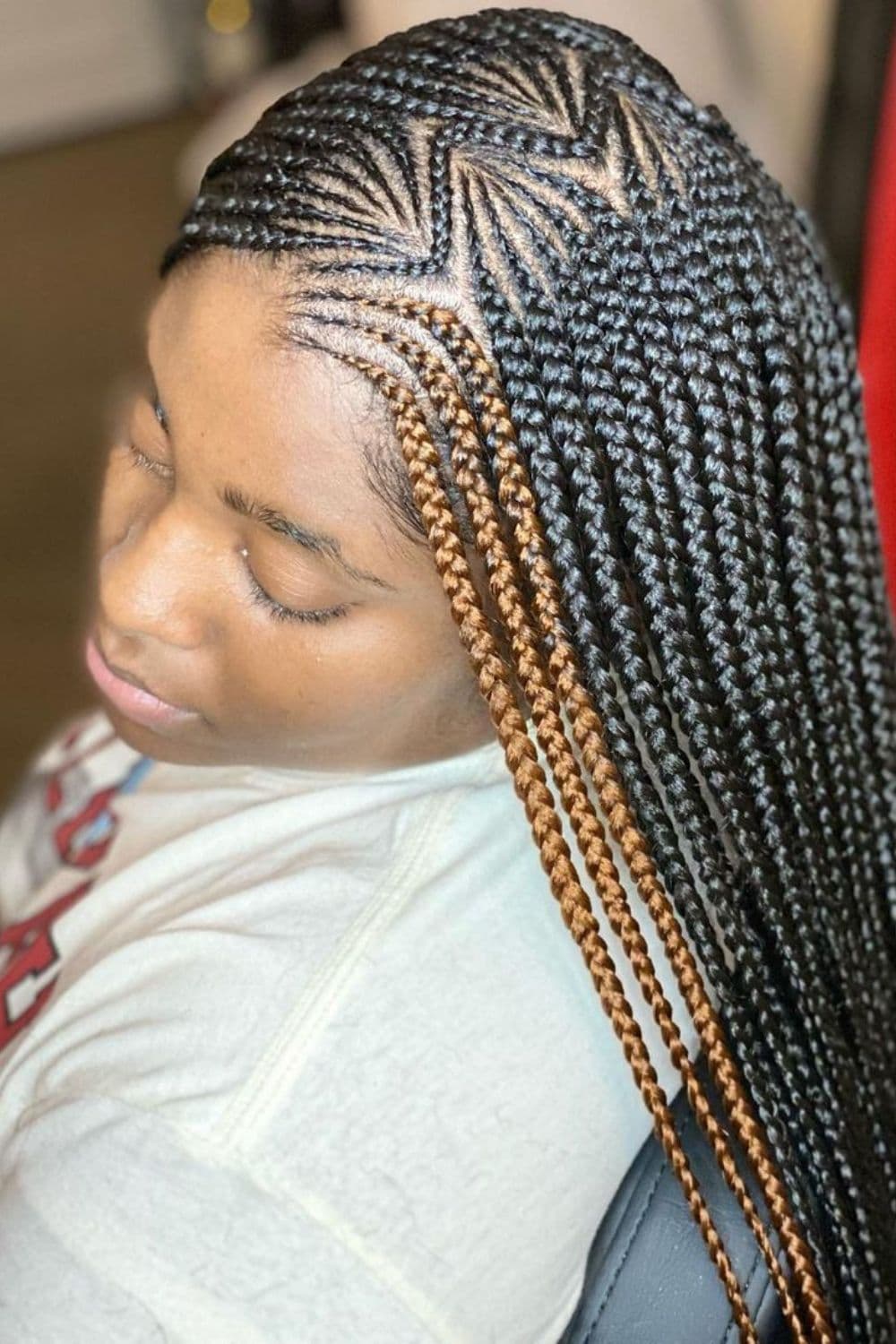 Side view of a woman with zig-zag middle-part tribal braids.