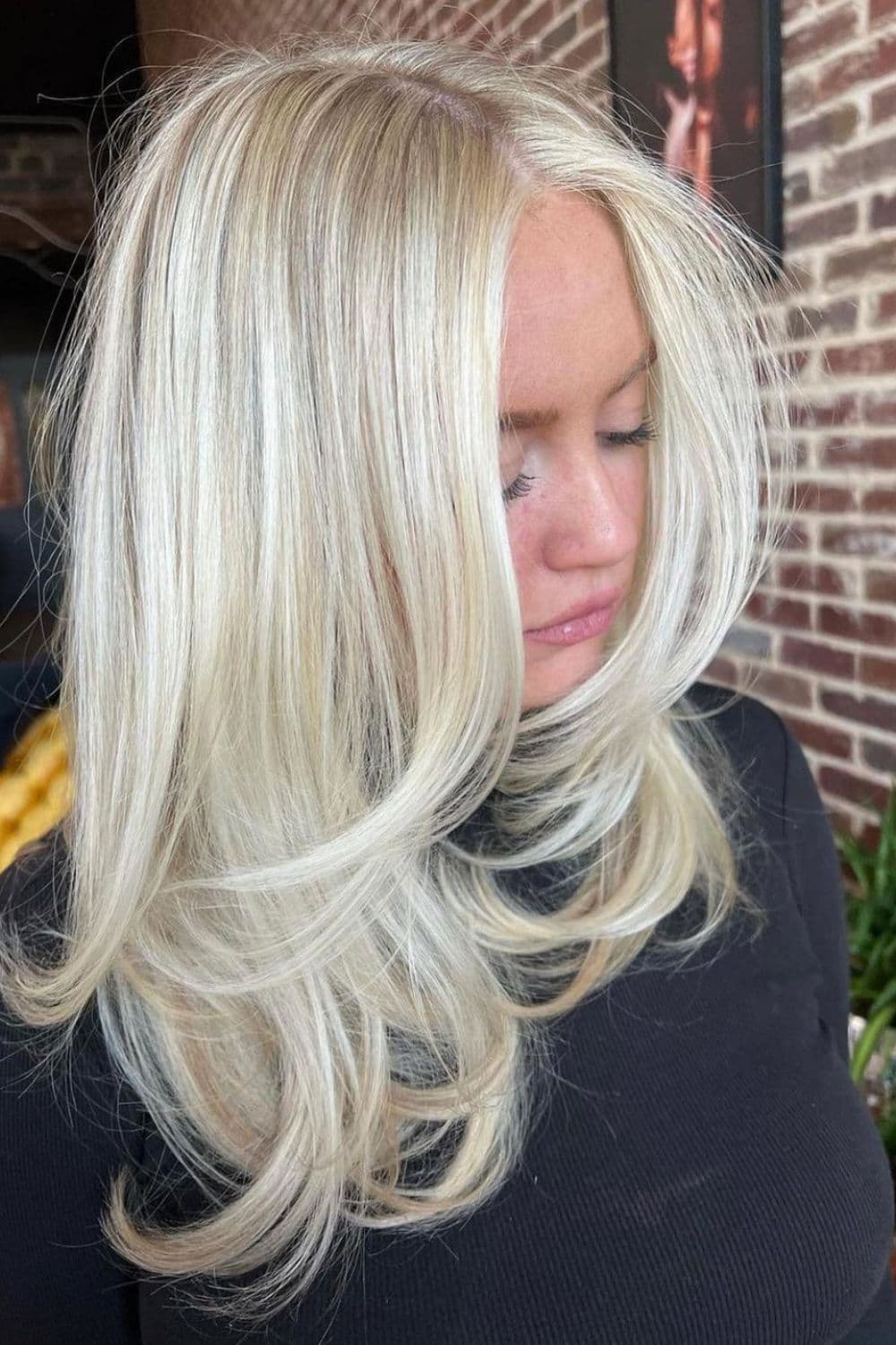 A woman with medium-length 90s platinum blonde hair.