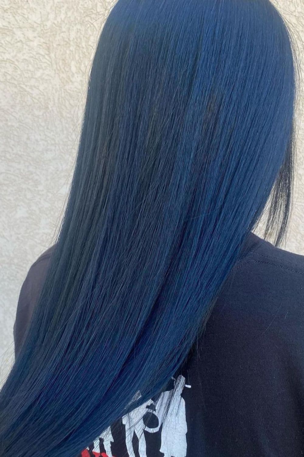 A woman with long straight all-over blue black hair.