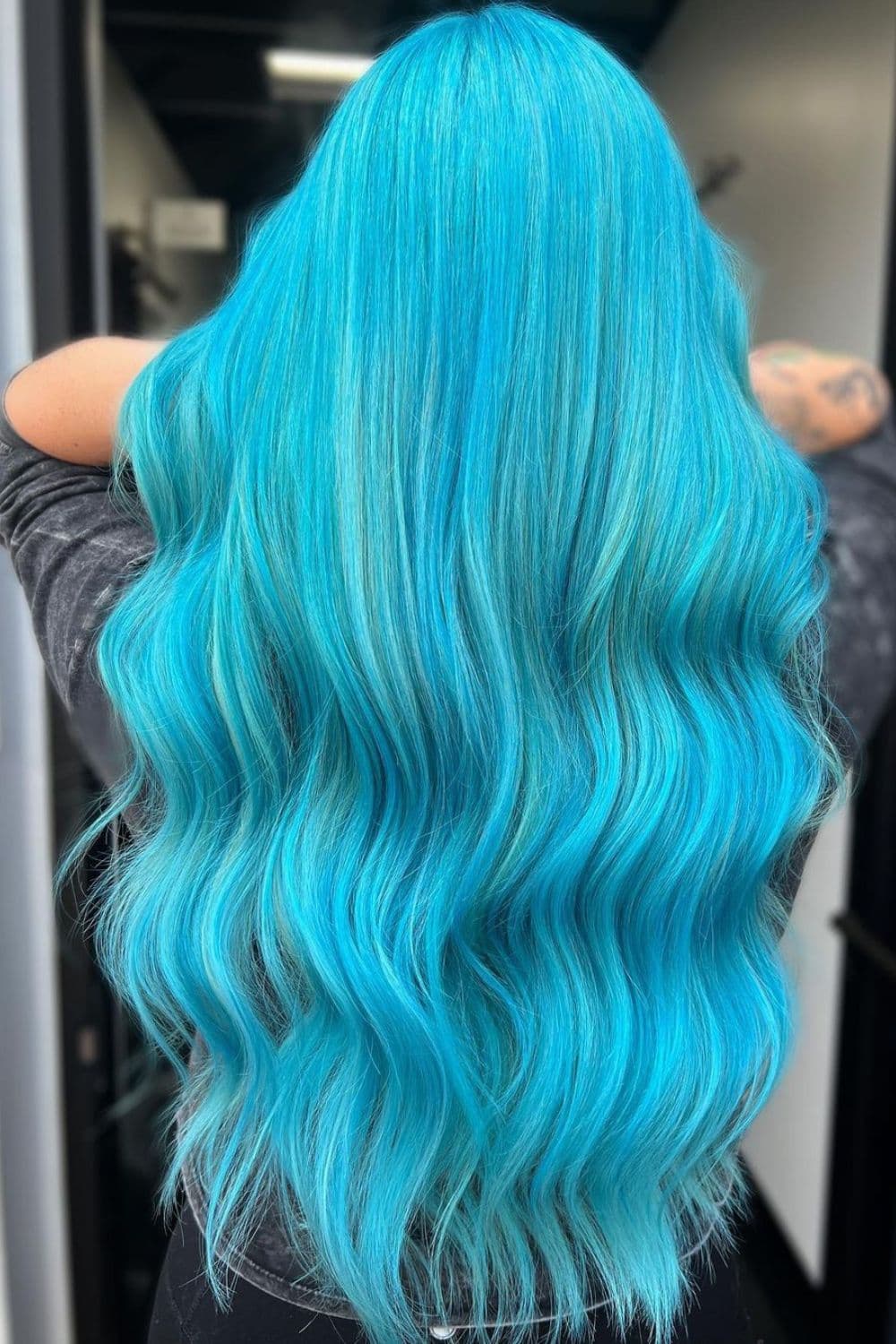 A woman with long wavy aqua blue hair.