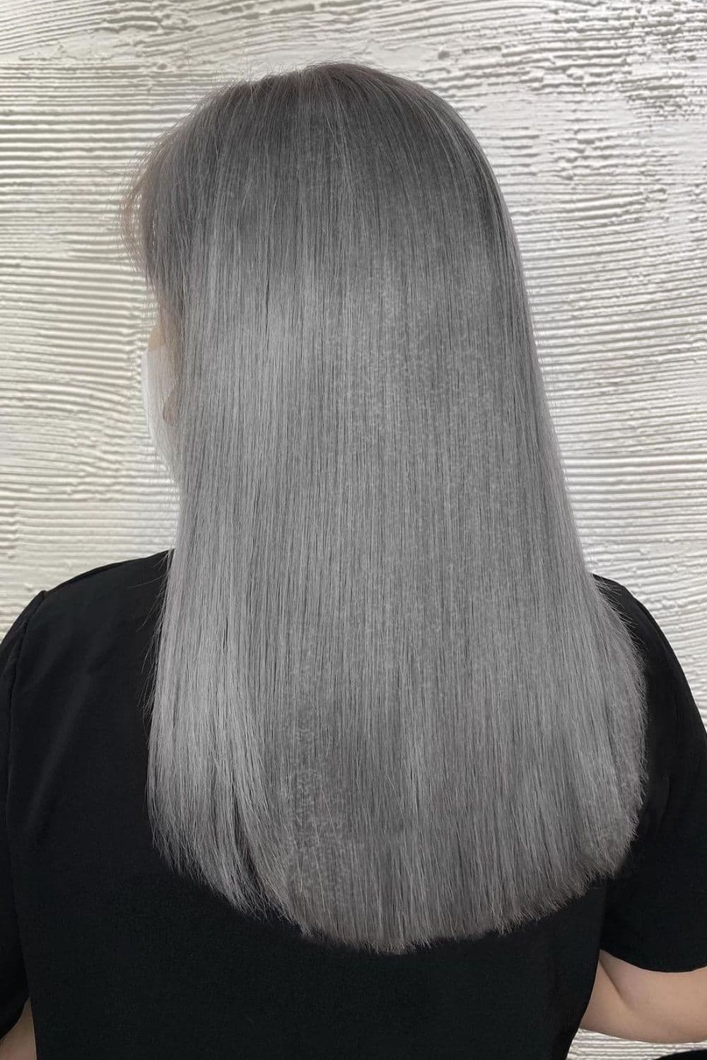 A woman with medium-length straight ash colored silver hair.