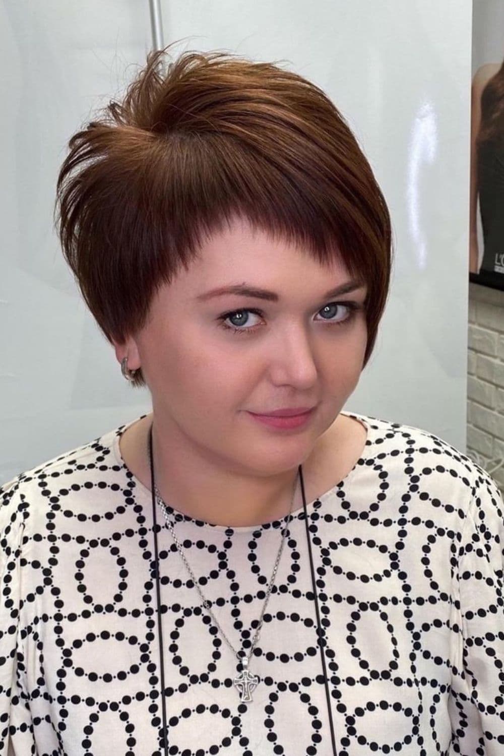 A woman with a brown asymmetrical pixie cut.