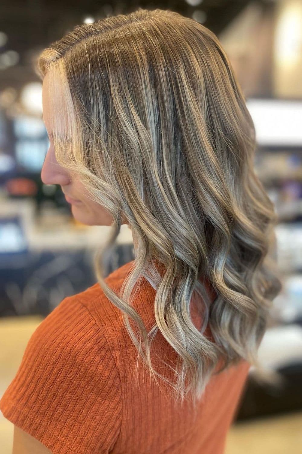 A woman with balayage with blonde money piece highlights.