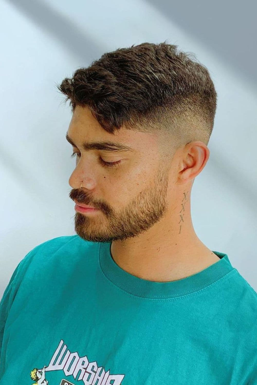 Side view of a man with a beard fade cut.