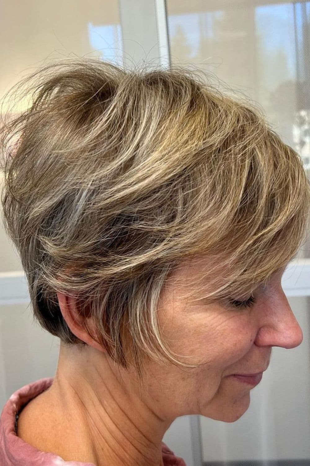 A woman with a natural gray bixie cut.
