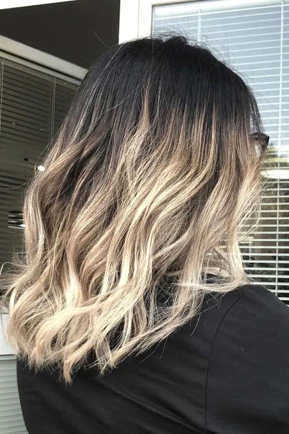A woman with black hair and blonde ombre.
