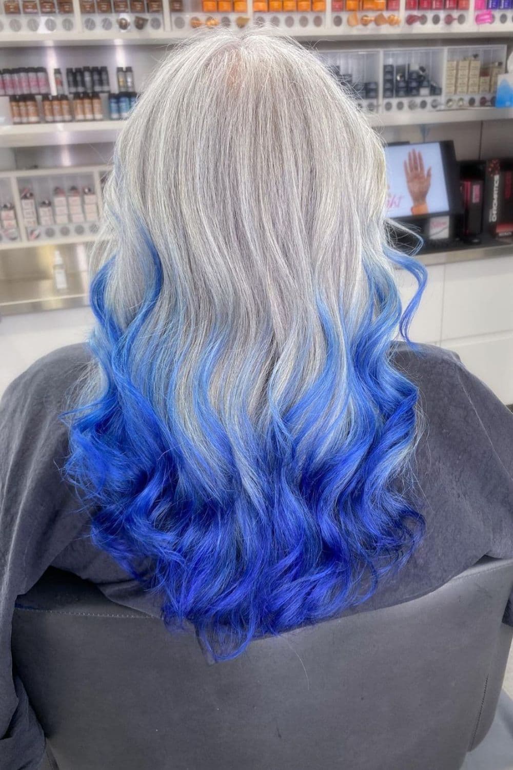 A woman with silver blonde to blue hair ombre.