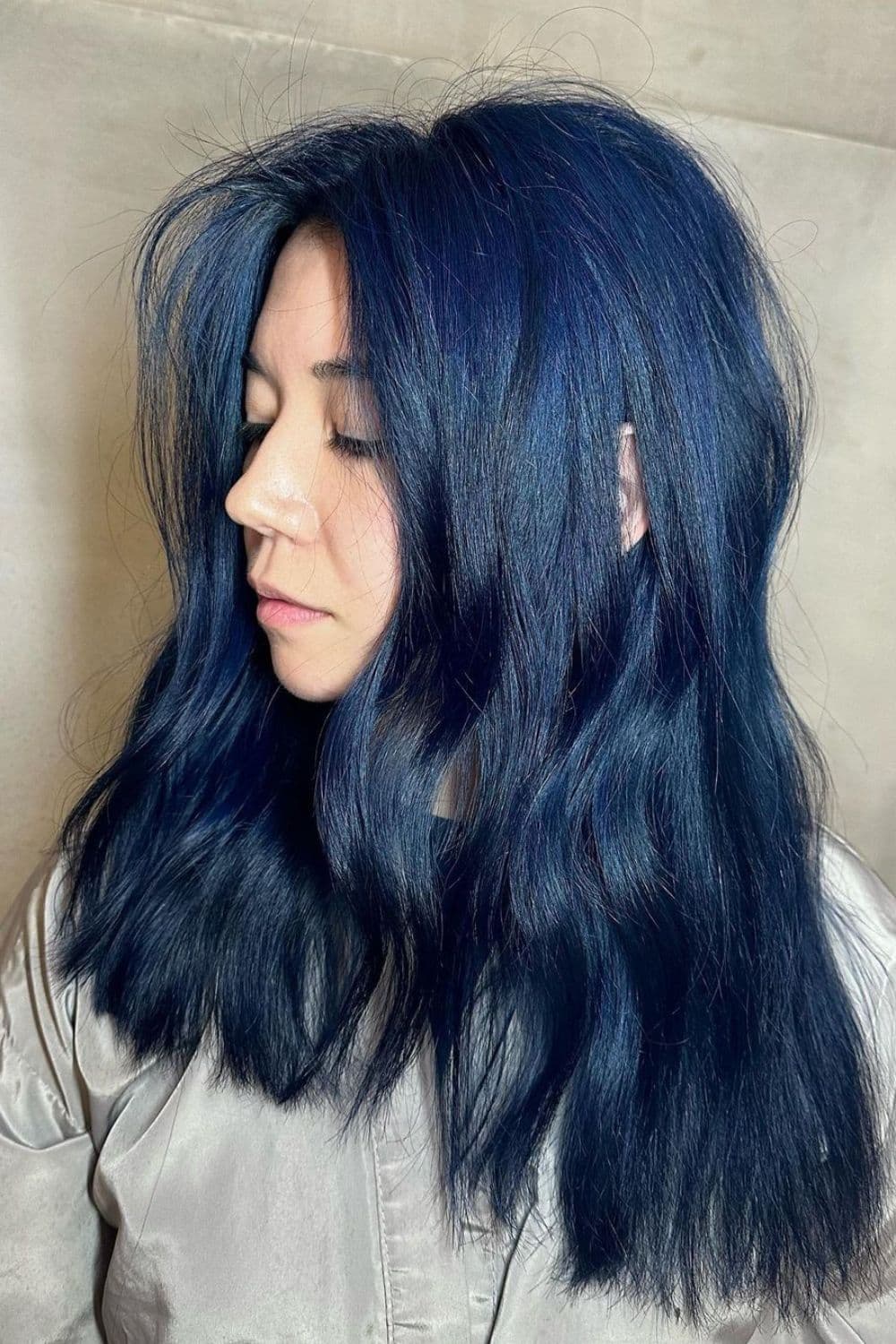 A woman with medium length wavy blue black hair.