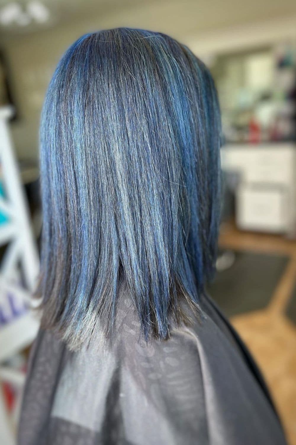 A woman with a long bob with blue highlights.