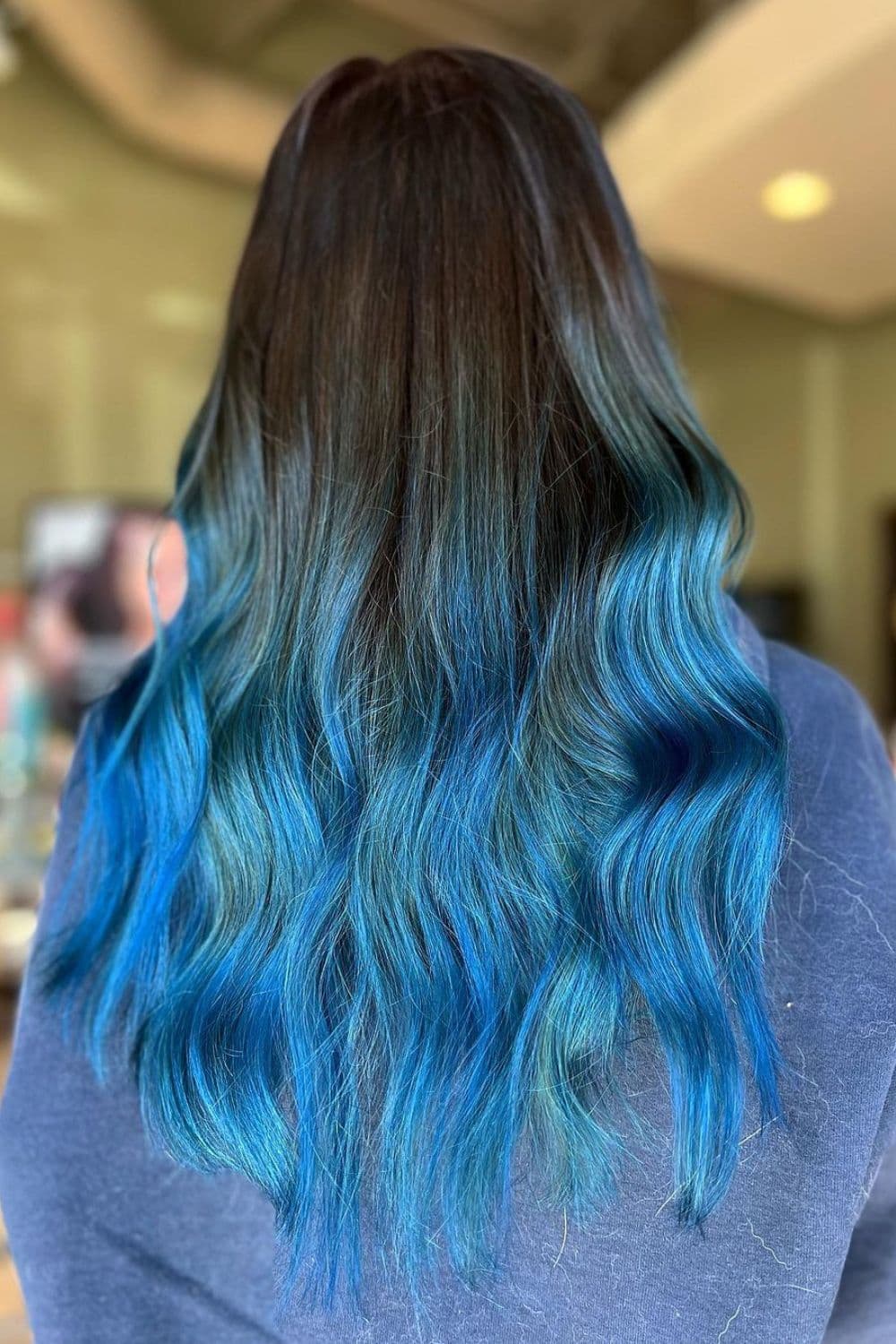 A woman with long dark hair to blue ombre.