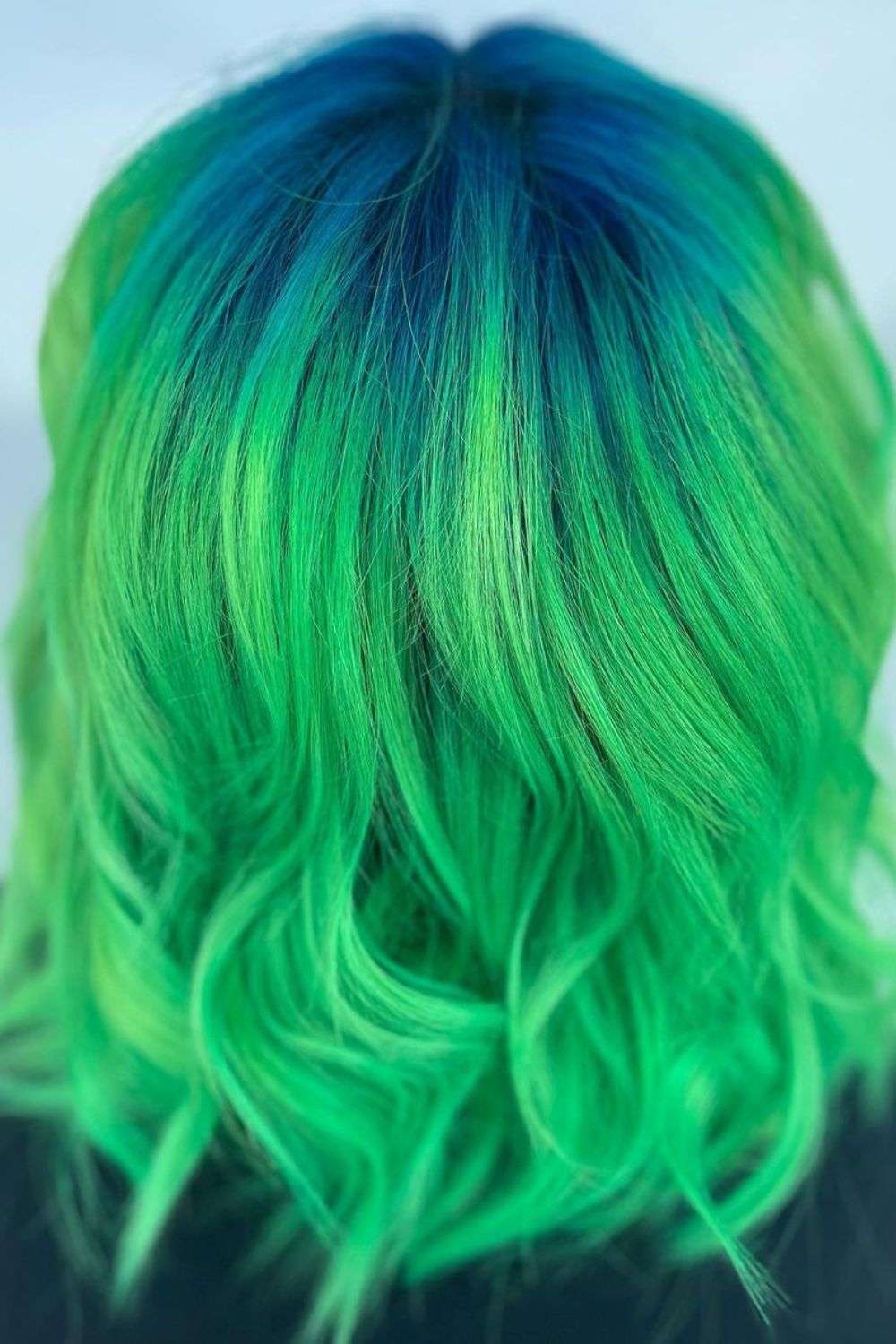 Close-up image of a woman's hair with blue-to-green ombre.