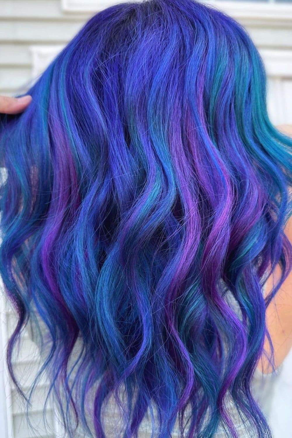 A woman with blue hair with violet tones with beach waves.