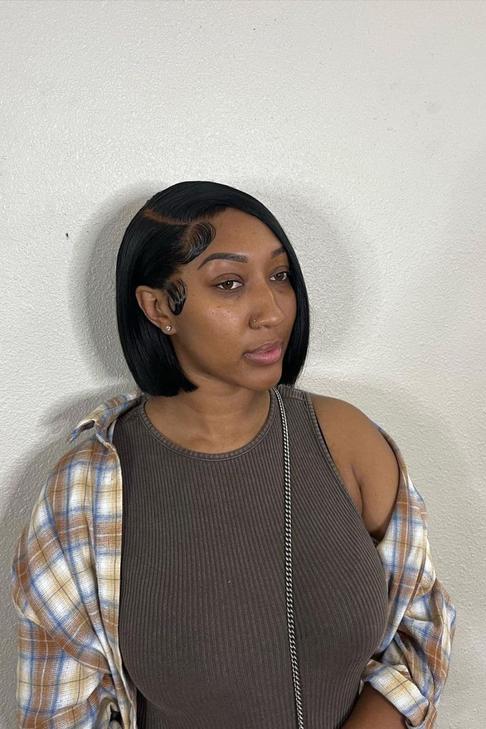 A black woman with a blunt bob cut with a deep side part.