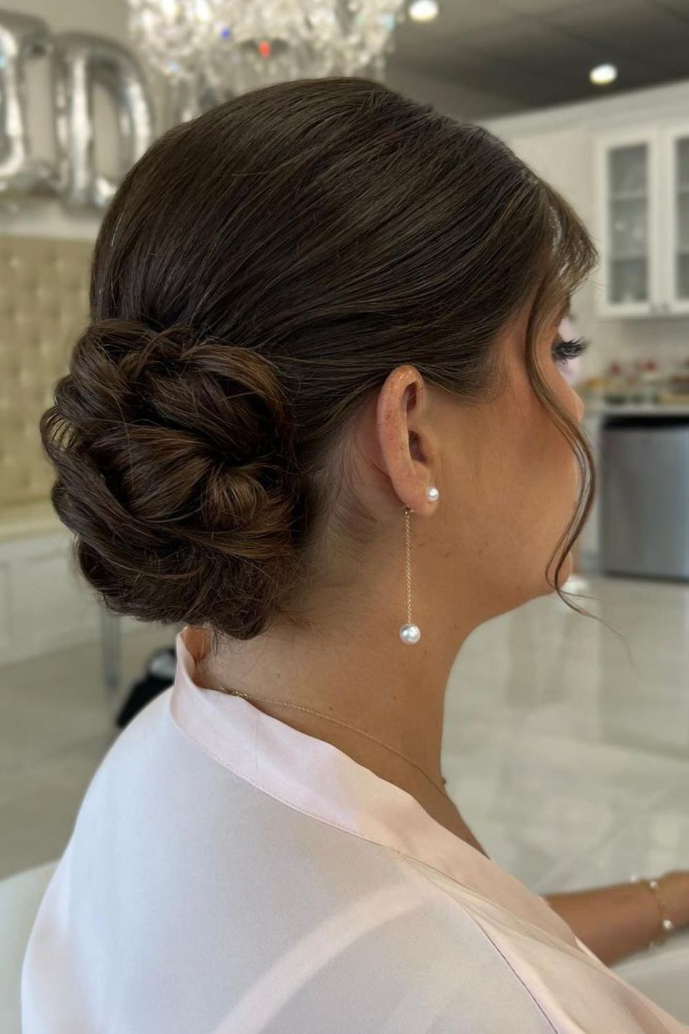 A woman with a brown braided low bun.