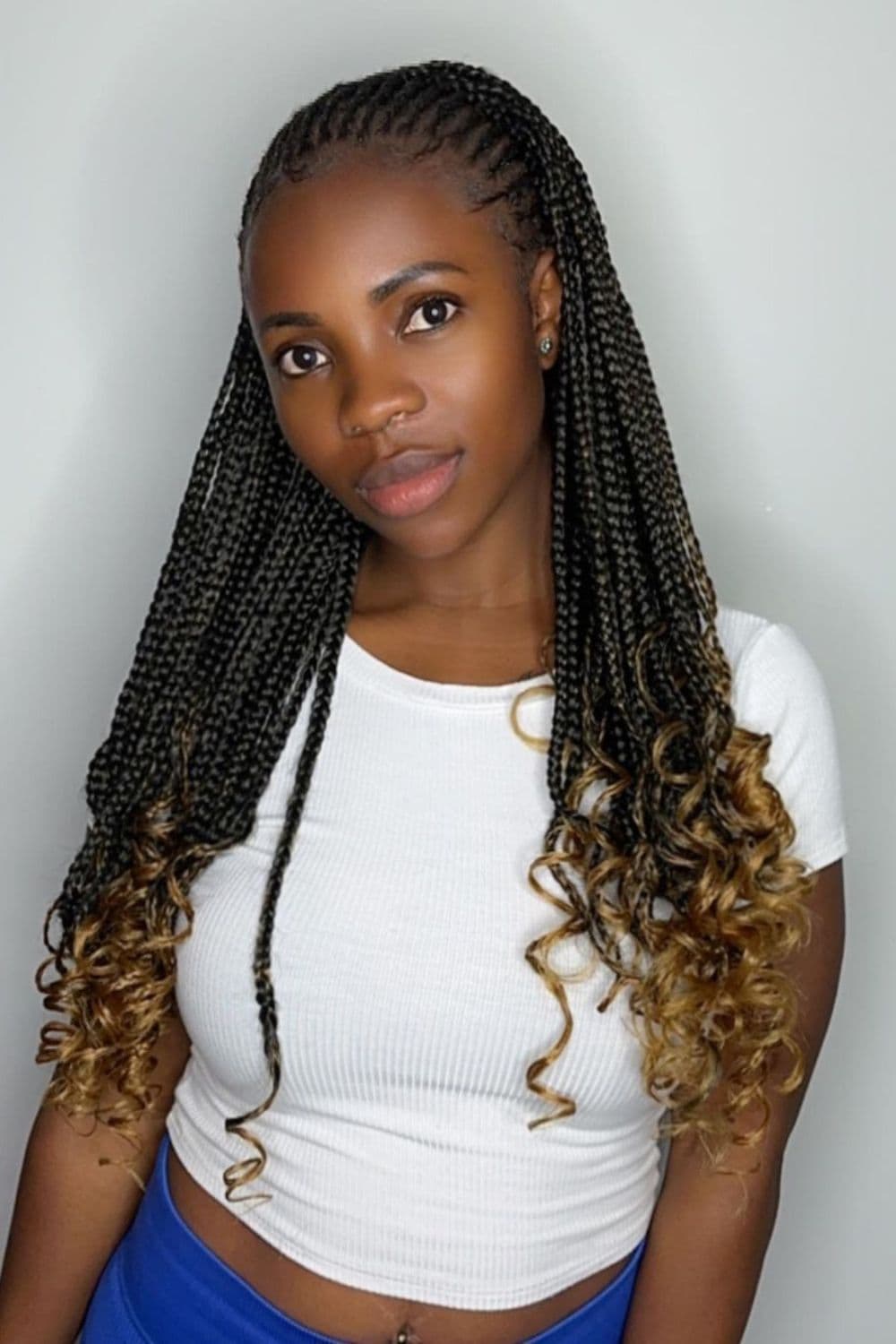 A woman with half feed in cornrows and half knotless braids with curly ends.