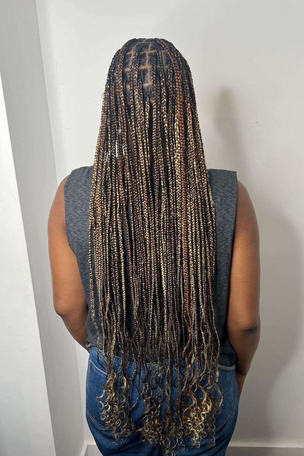 A woman with long knotless braids with highlights.